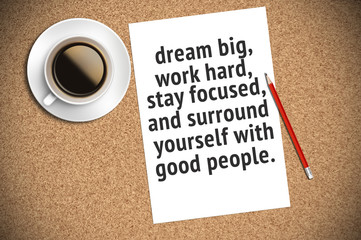 Inspirational motivating quote on paper with coffee, pencil and cork background. Dream big, work hard, stay focused, and surround yourself with good people.