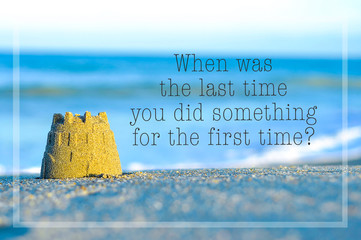 Inspirational motivating quote on blur beach view with sand castle. When was the last time you did something for the first time? - 129757353