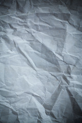 Recycled crumpled gray paper background dark edged.