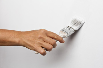 Hand paints the white wall brush
