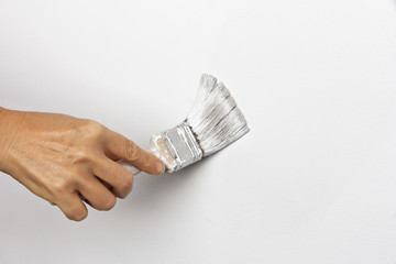 Hand paints the white wall brush