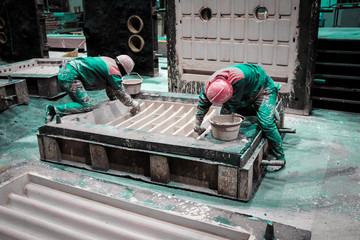 Foundry worker preparing casting mold.