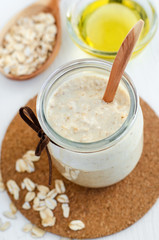 Homemade oatmeal mask in a glass jar. Gentle scrub for sensitive skin. Diy cosmetics. 