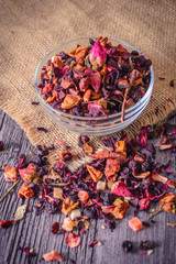 Dry tea in plate on rustic background