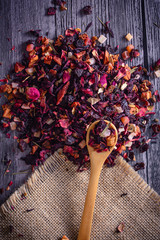 Mix tea with dried fruits and dried flowers and wooden spoon