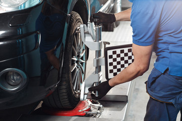 Grid sensor sets mechanic on auto. Car stand with sensors wheels for alignment camber check in workshop of Service station.