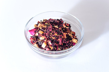 Mix of dry tea and a wooden spoon on white background