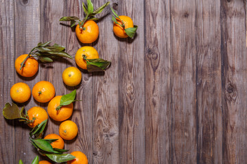 Naklejka na ściany i meble Orange mandarins fruits with leaves on white wooden background
