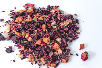 Mix of dry tea and a wooden spoon on white background