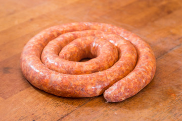 Rolled raw red sausage on the table