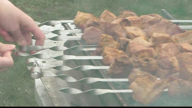 Barbeque skewers with meat cooking on hot coal ember brazier Outdoors picnic concept.
