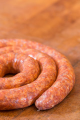 Rolled raw red sausage on the table