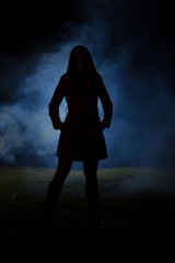spooky silhouette girl at night with smoke in background