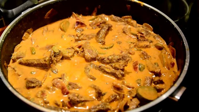 Boiling Stroganoff sauce with beaf strips in pan.