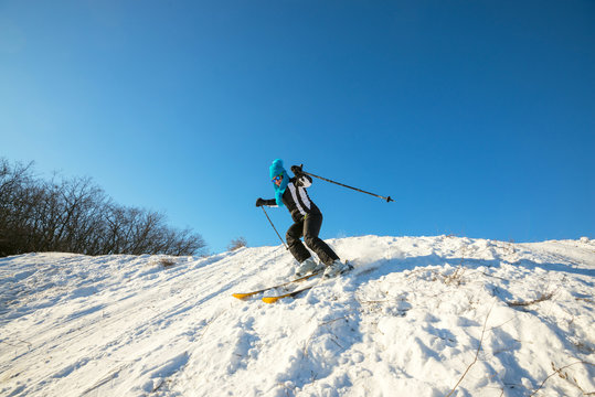 Woman skier skiing downhill in the winter forest