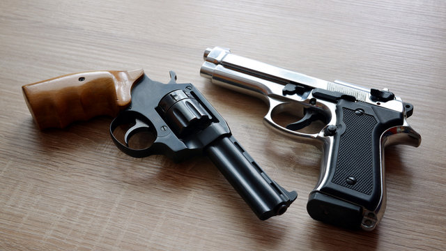 Two Pistols On Wooden Board.