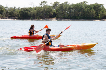 two kayak making tourism in the calm river boy and girl