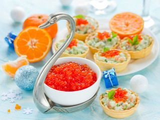 Festive Christmas table with refreshments - red caviar in a bowl