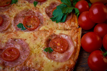 Various ingredients for pizza. Flour, butter, mushrooms, cucumbers, cherry tomatoes, olives,Mozzarella  , sausage, cheese. Dark background.