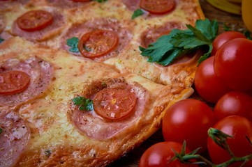 Various ingredients for pizza. Flour, butter, mushrooms, cucumbers, cherry tomatoes, olives,Mozzarella  , sausage, cheese. Dark background.