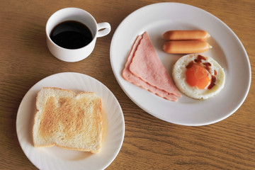 Set of american breakfast, toast, fried egg, ham, and sausage wi