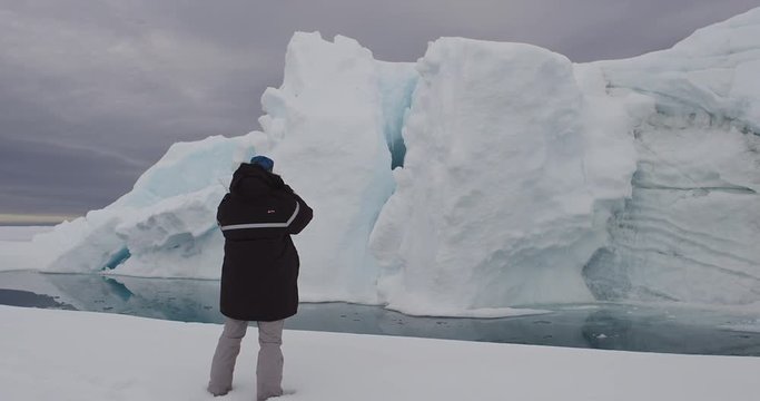 Close photographer steps forward and takes photo of iceberg
