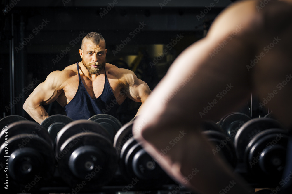 Wall mural a male bodybuilder in front of a mirror