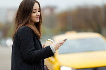 Girl with phone near taxi