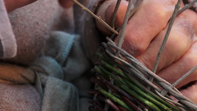 particular on hands of a elderly man weaving a basket with gorse