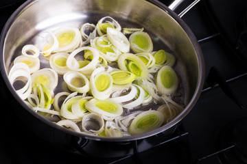 Fresh slices of leek cooked on a frying pan