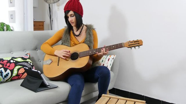 young brunette woman with a guitar and a tablet