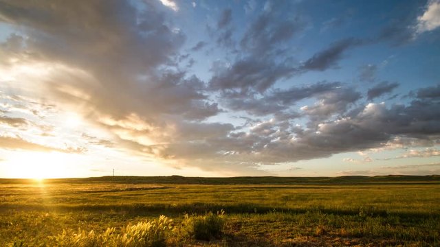 Time lapse - Clouds race towards rising sun on prairie morning