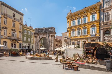Pula, Croatia-10 June, 2016. Ancient Roman triumphal arch or Golden Gate and square decorated for the Days of Antiquity - Pula Svperiorvm on 10 June, 2016 in Pula, Croatia.  - obrazy, fototapety, plakaty