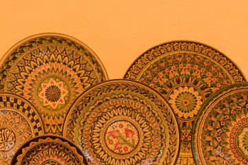 Beautiful plate with floral ornament on a background of beige wall
