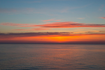 Sunset at sea with clouds and horizon