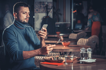 Handsome man photographing food at the restaurant