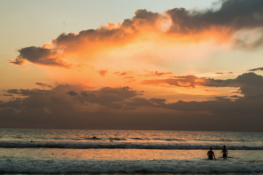 Beautiful sunset of Kuta Beach, Bali, Indonesia. Silhouettes of people at sunset on Kuta beach in Bali, Indonesia
