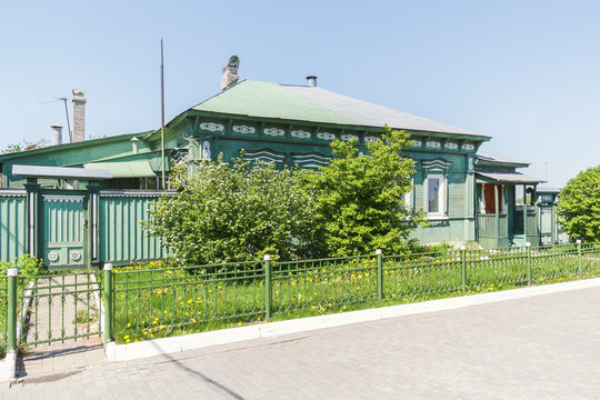 Дом с деревянными украшениями в зелени