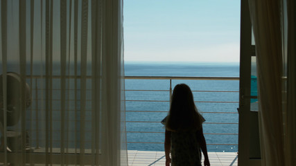 Mom and daughter go to the balcony with the sea view from the guest room