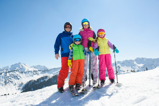 Happy family enjoying winter vacations in mountains . Ski, Sun,Snow and Fun.