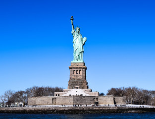 The Statue of Liberty is standing with a clear blue sky in winter