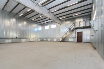 empty parking garage, warehouse interior with large white gates and windows inside