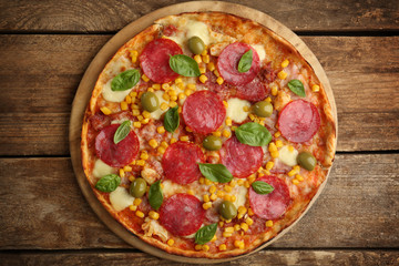 Tasty pizza on wooden background