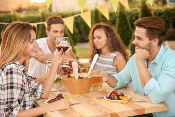 Young friends having barbecue party in garden