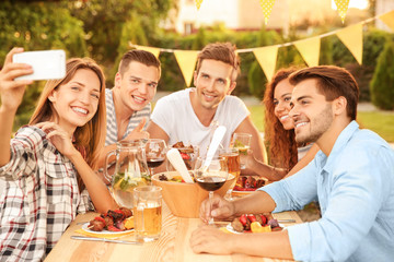 Friends taking selfie during barbecue picnic