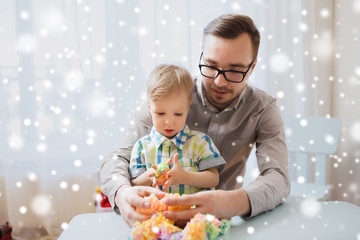 father and son playing with ball clay at home