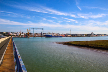 Landscape of port of Huelva with cranes, fishing boat in shipyard and mall in coast of Huelva, Andalusia, Spain.