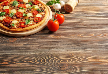 Fresh pizza with tomatoes, cheese and mushrooms on wooden background