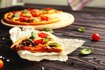 Fresh pizza with tomatoes, cheese and mushrooms on wooden background