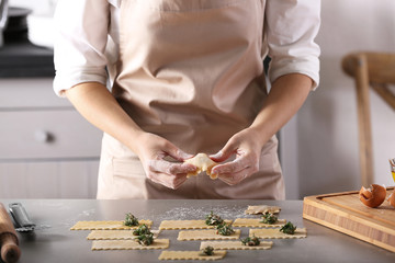 Woman making ravioli on table